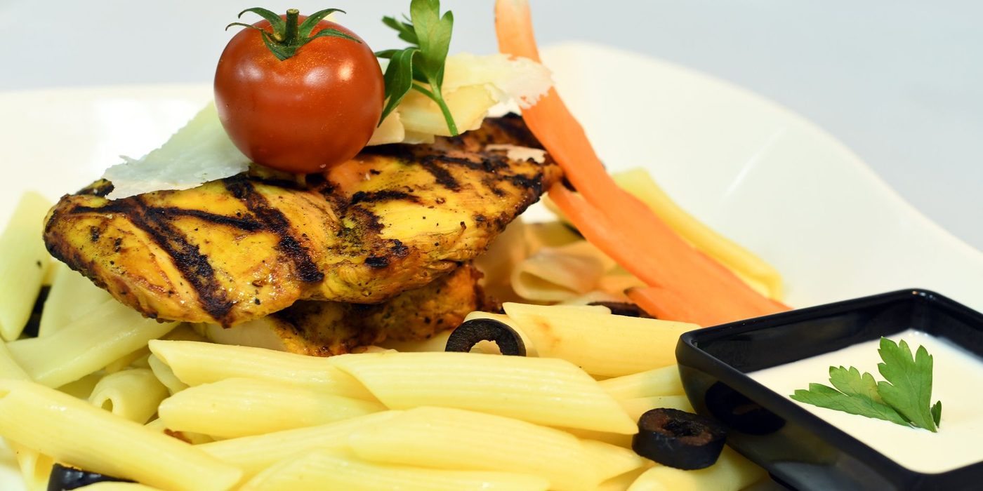 An illustrative grilled chicken and pasta plate
